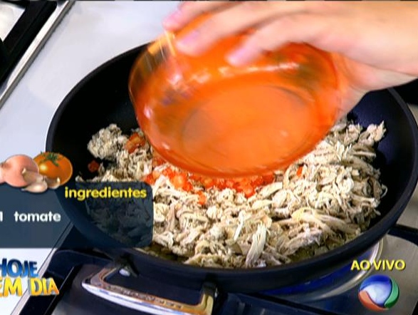Refogue a cebola e adicione o frango desfiado. Coloque o tomate, a salsa picada e o colorau. Acerte o sal e a pimenta ou cubos de queijo.